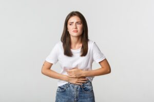 mulher jovem sofrendo com intolerâncias alimentares